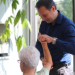Occupational Therapist performing manual therapy on a older patient.